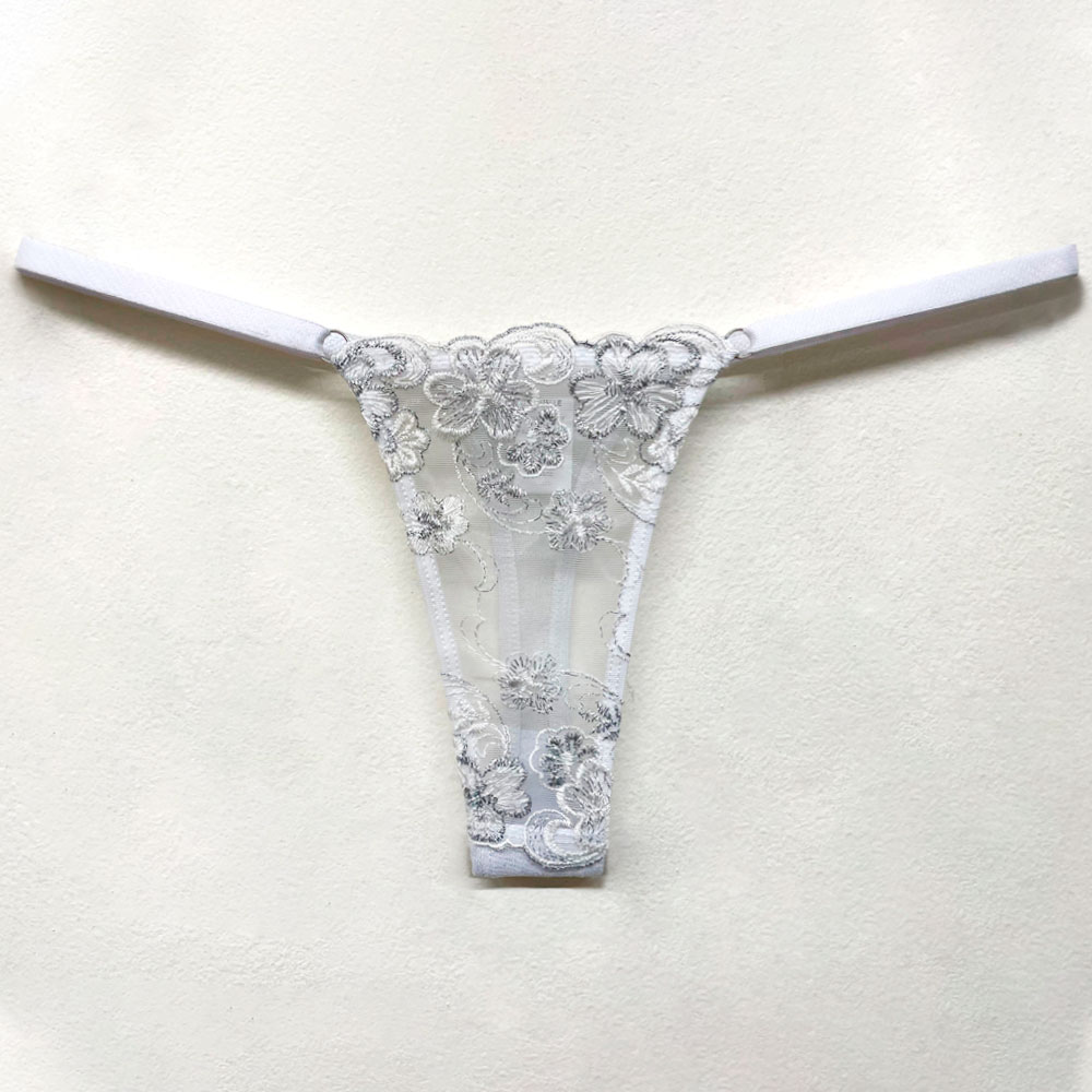 Calcinha String Fio Dental Sensual em Tule Bordado Branca, foto detalhe da parte frontal com o bordado em fios prateados e a regulagem lateral