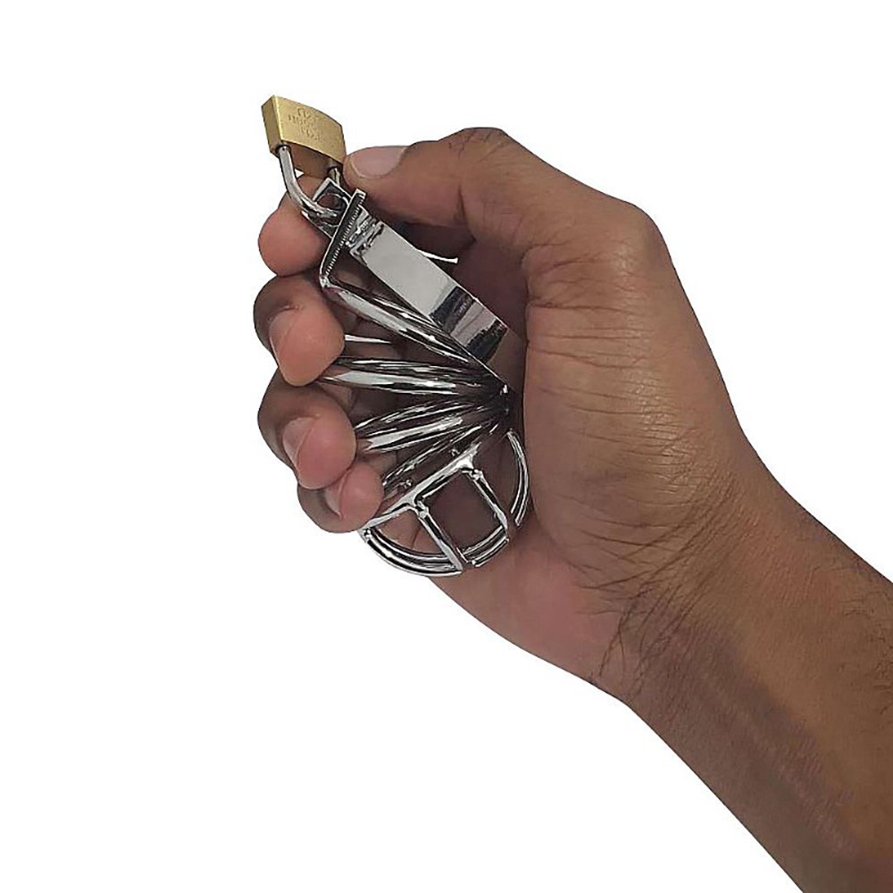 Cinto de castidade masculino em metal vazado sendo segurado por uma m�o, mostrando o tamanho e a ergonomia do dispositivo
