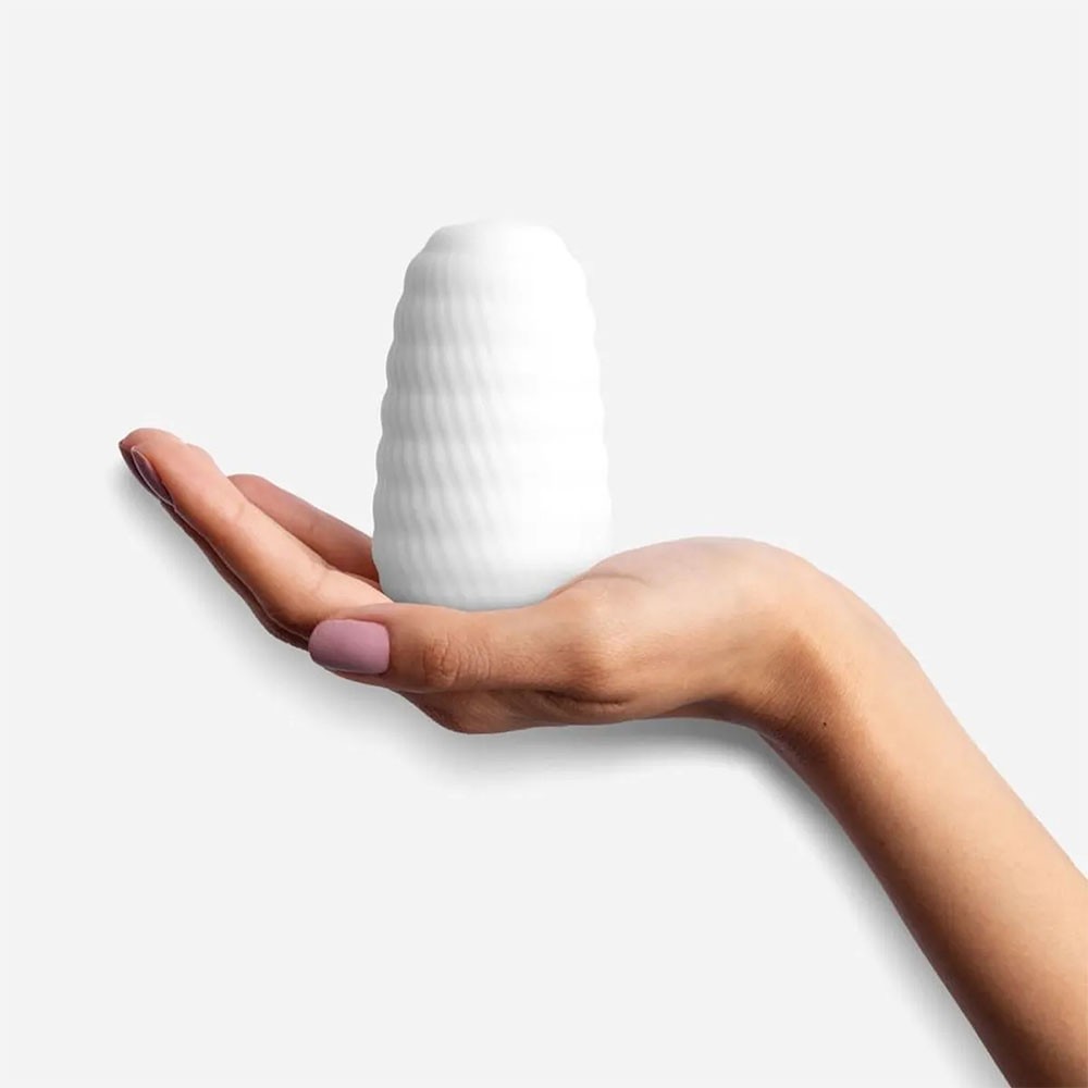 Vista lateral do Masturbador Masculino Hand Experience Branco na palma da m�o, destacando o design ergon�mico e a cor branca suave