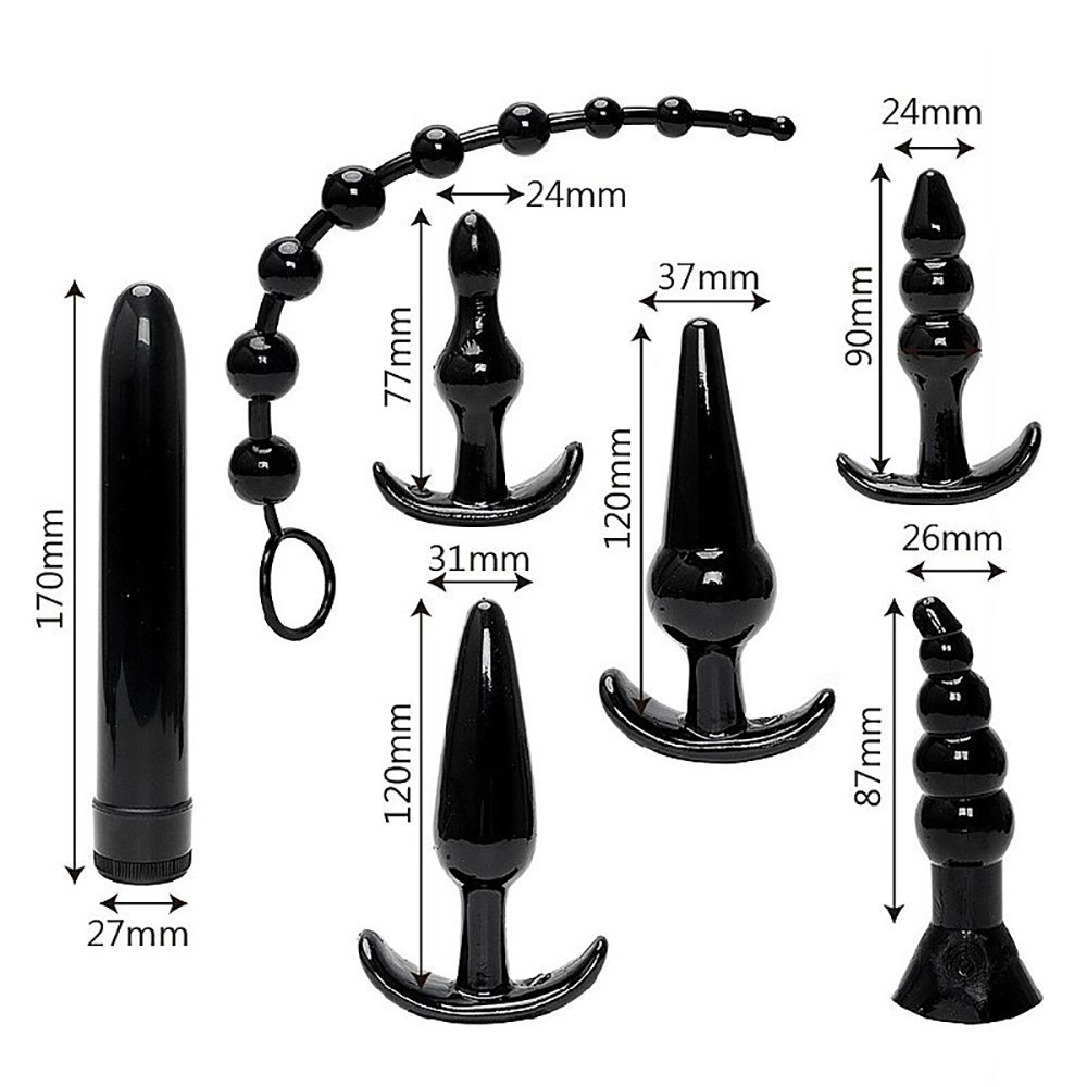 Vibrador personal preto ao lado dos plugs anais, destacando a textura suave e a cor uniforme de todos os itens do kit