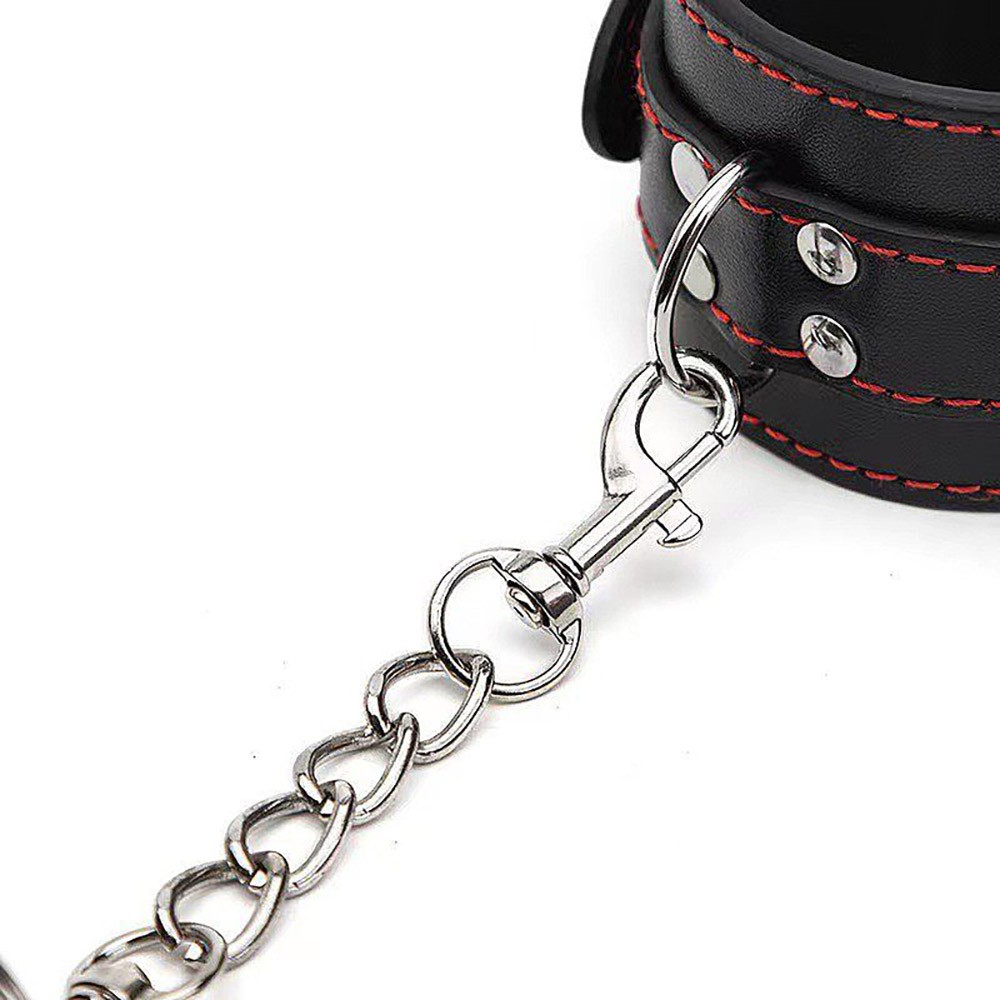Kit Bondage com algemas e venda empilhados, mostrando a textura do PU e a corrente de metal