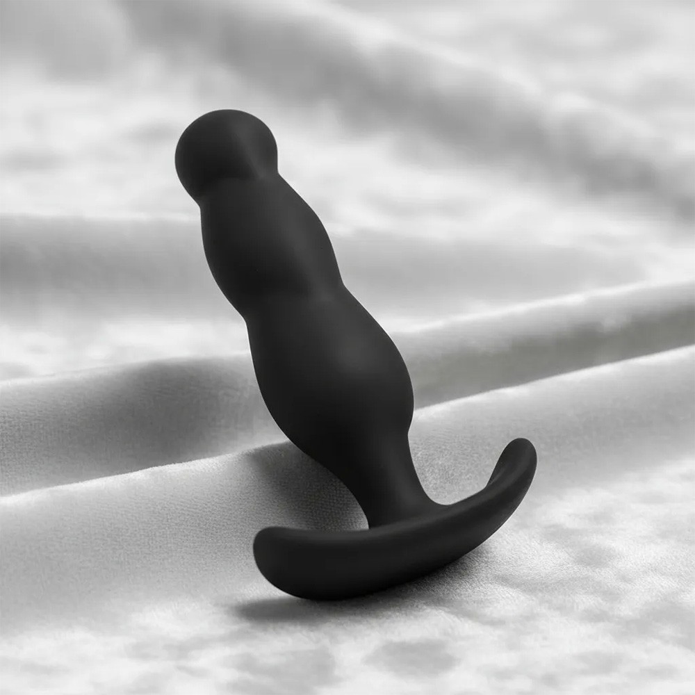 Plug Anal Mini Preto em Silicone M�dico, foto ambientada em tecido, mostrando a base de seguran�a
