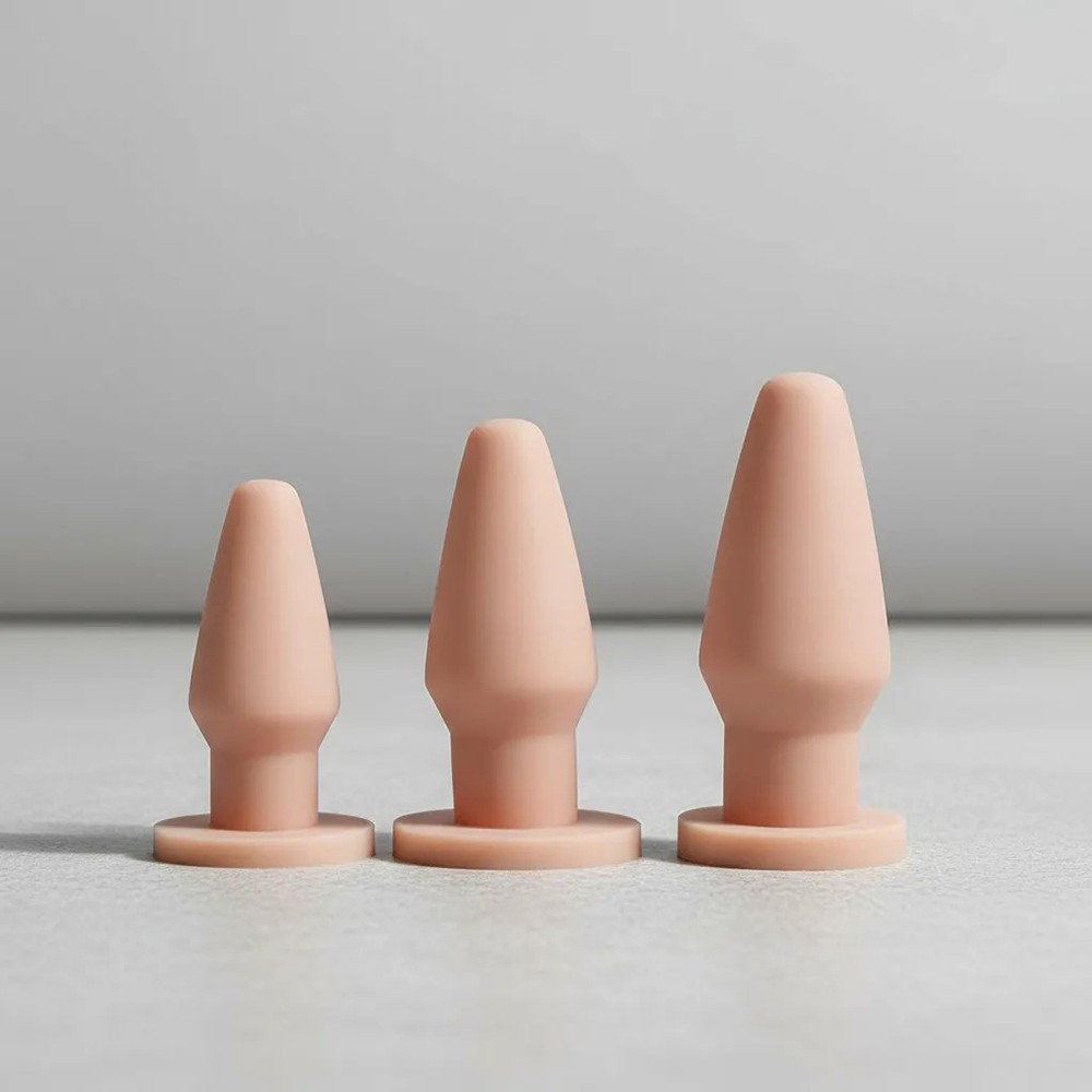 Kit Plug Anal Butt com 3 plugs de diferentes tamanhos na cor bege sobre fundo cinza claro