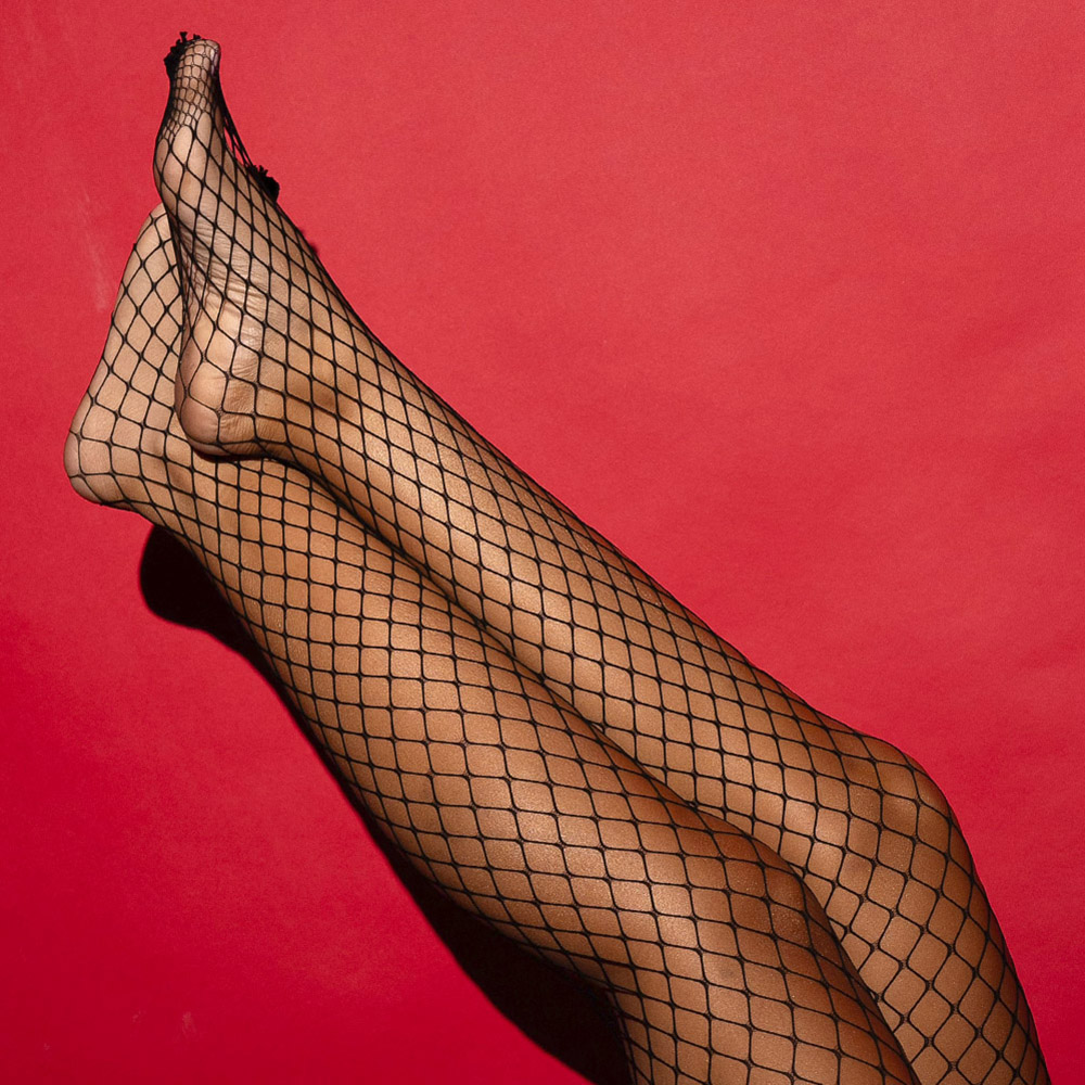 Meia Cal�a Arrast�o Sensual Sexy Trama Larga Cl�ssica Preta, vista de pernas cruzadas no tornozelo e p�s em destaque