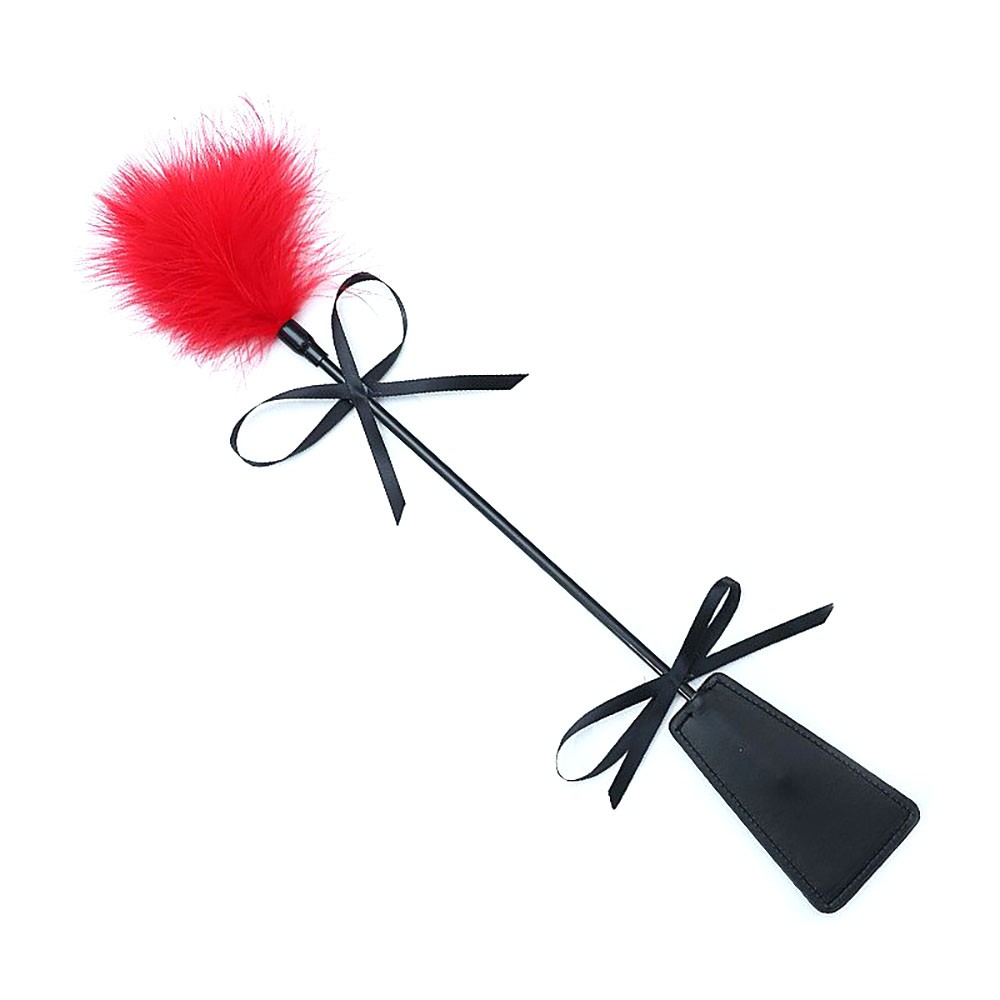 Chibata em PU com Plumas em vista lateral diagonal, com cabo preto e plumas vermelhas, destacando o la�o na p�.