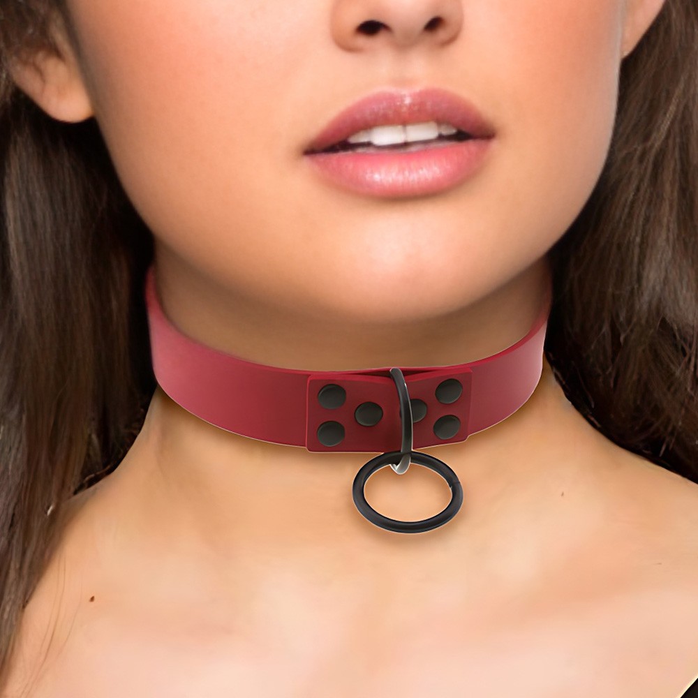 Close-up da argola metalica preta e rebites na Coleira Chocker Vermelha, com foco nos detalhes do acabamento