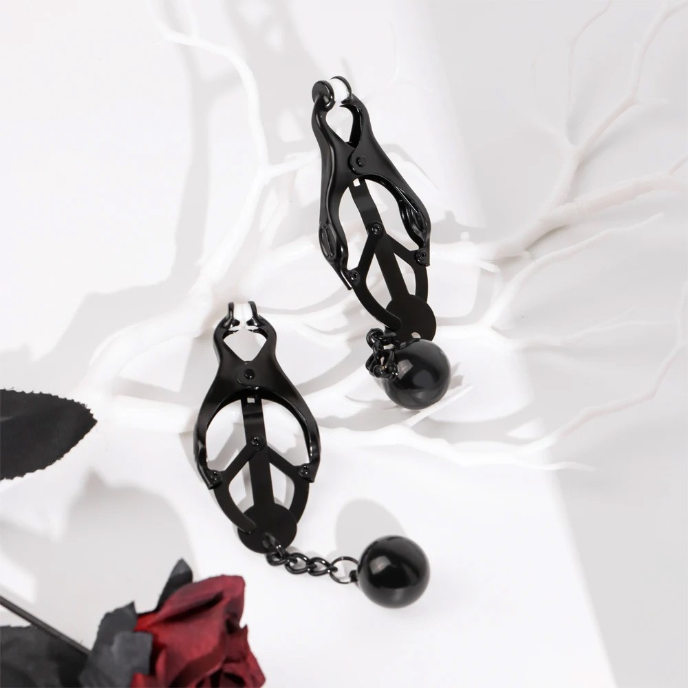 Par de prendedores de mamilo em metal preto estilo japon�s com bolas, ambientado para uma atmosfera sensual