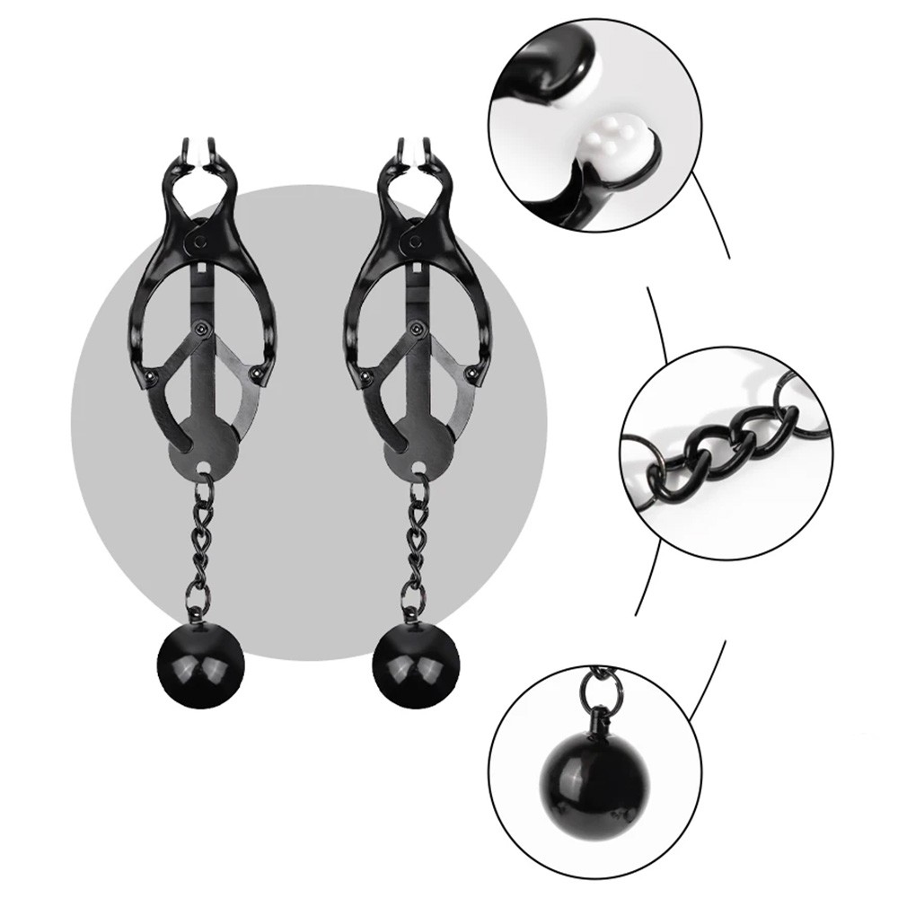 Prendedores de mamilo em metal preto estilo japon�s com bolas, em detalhe, mostrando os protetores de silicone nas pontas da pin�a e a corrente com a bola