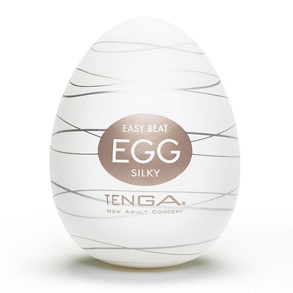 Masturbador Tenga EGG Silky em destaque, com um modelo segurando o produto no p�nis, mostrando a flexibilidade do material TPE