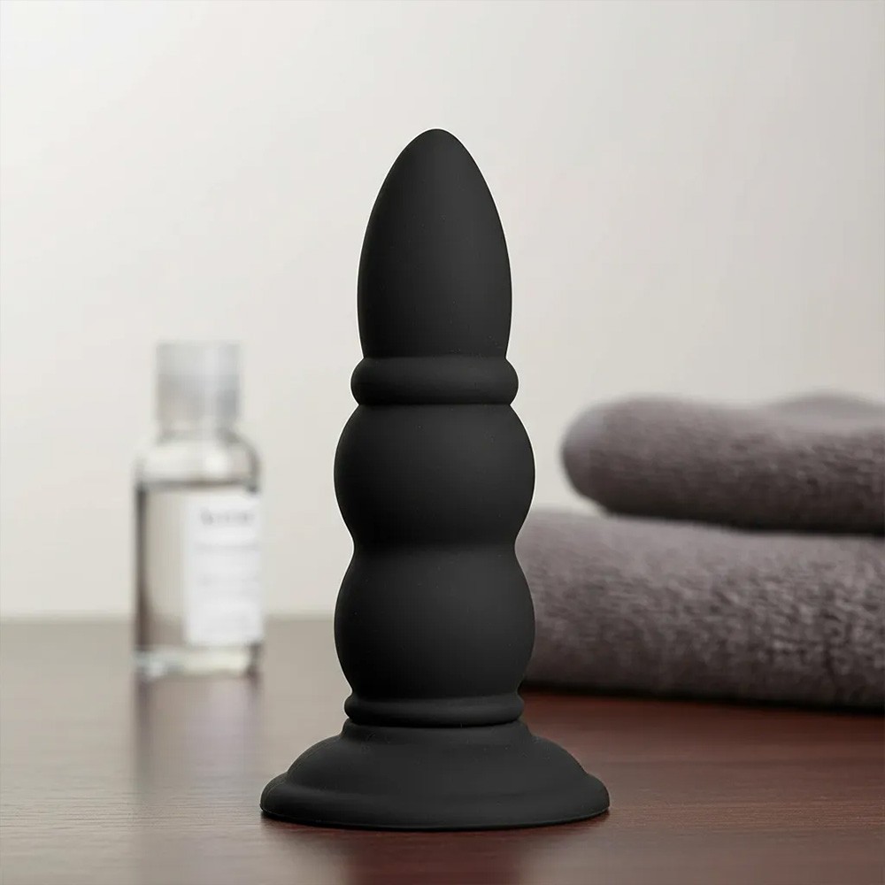 Plug Anal PVC Flex�vel Anelado Preto em imagem ambientada, destacando seu design e textura flex�vel