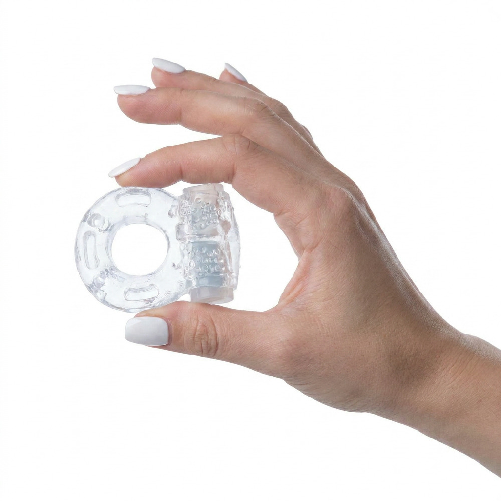 Anel Peniano Vibrat�rio Transparente com Estimulador Clitoriano Texturizado sendo segurado por uma m�o