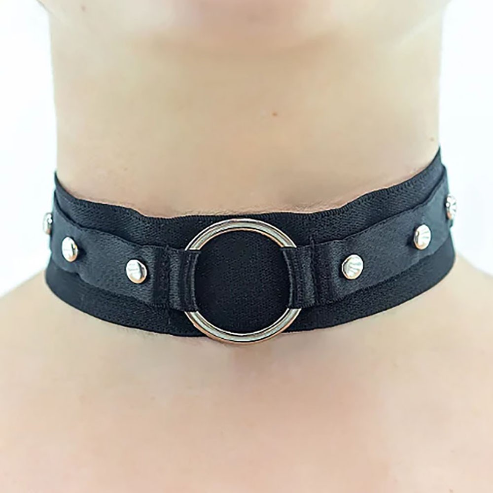 Choker preta com argola e detalhes em metal, vista frontal em um pescoco, destacando o design e a argola