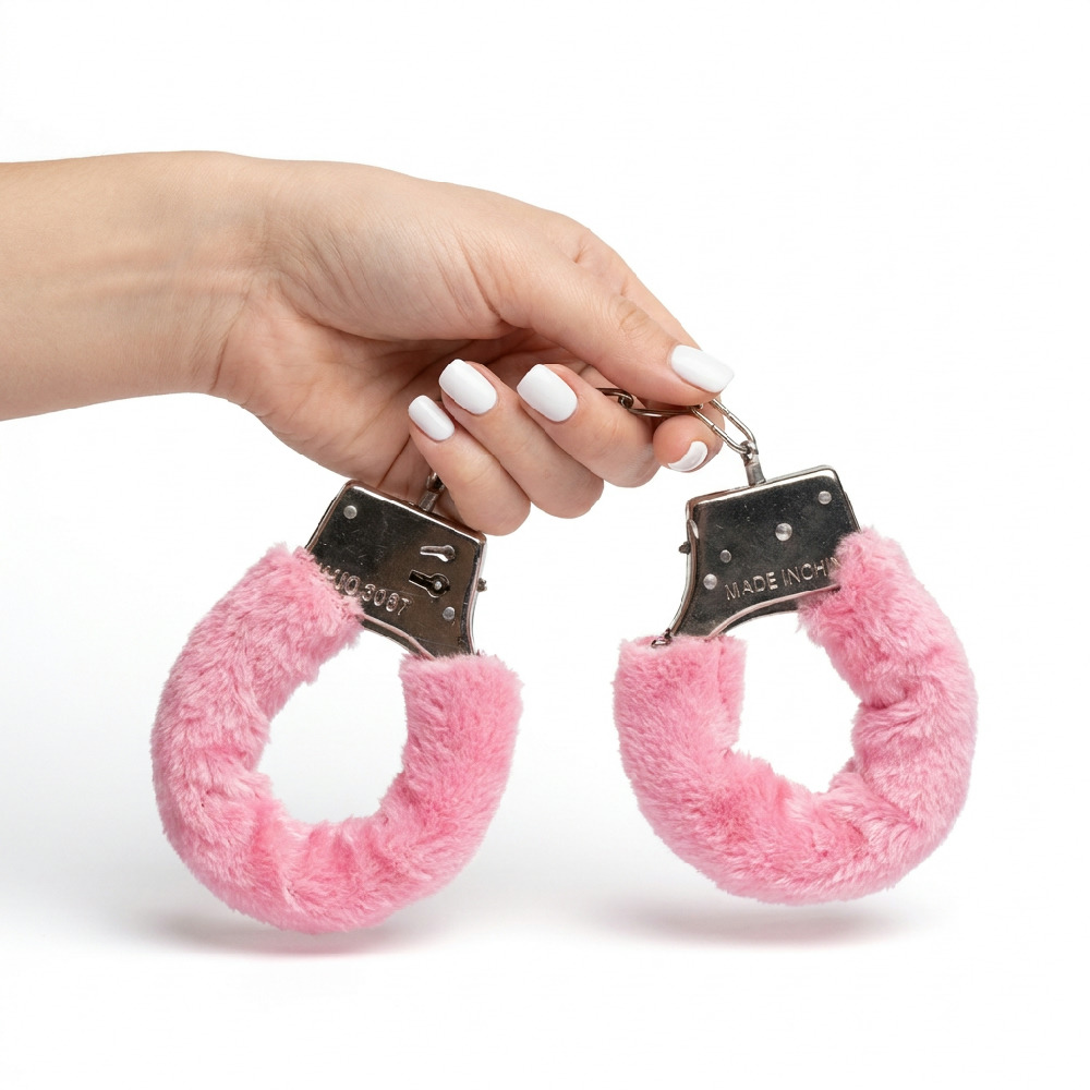 Algema para Fetiche Rosa com Corrente em Metal e Revestimento de Pel�cia sendo segurada pela m�o, mostrando o detalhe do metal e do tecido