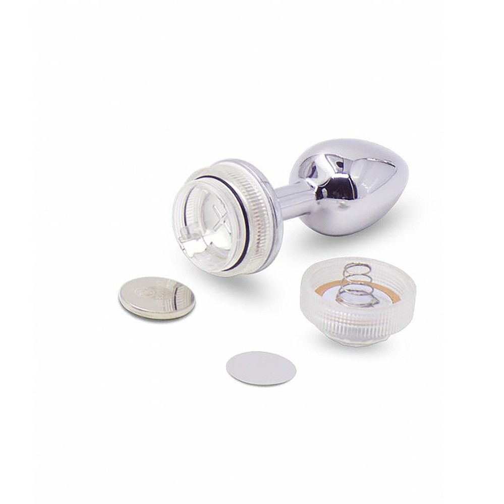 Base de luz LED do plug anal de a�o com as partes para bateria vis�veis, ao lado de bateria de disco