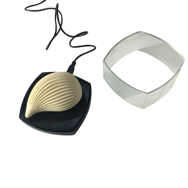 Vibrador Kushi Iroha by Tenga na base de carregamento USB, com a caixa protetora transparente ao lado, mostrando o sistema recarreg�vel