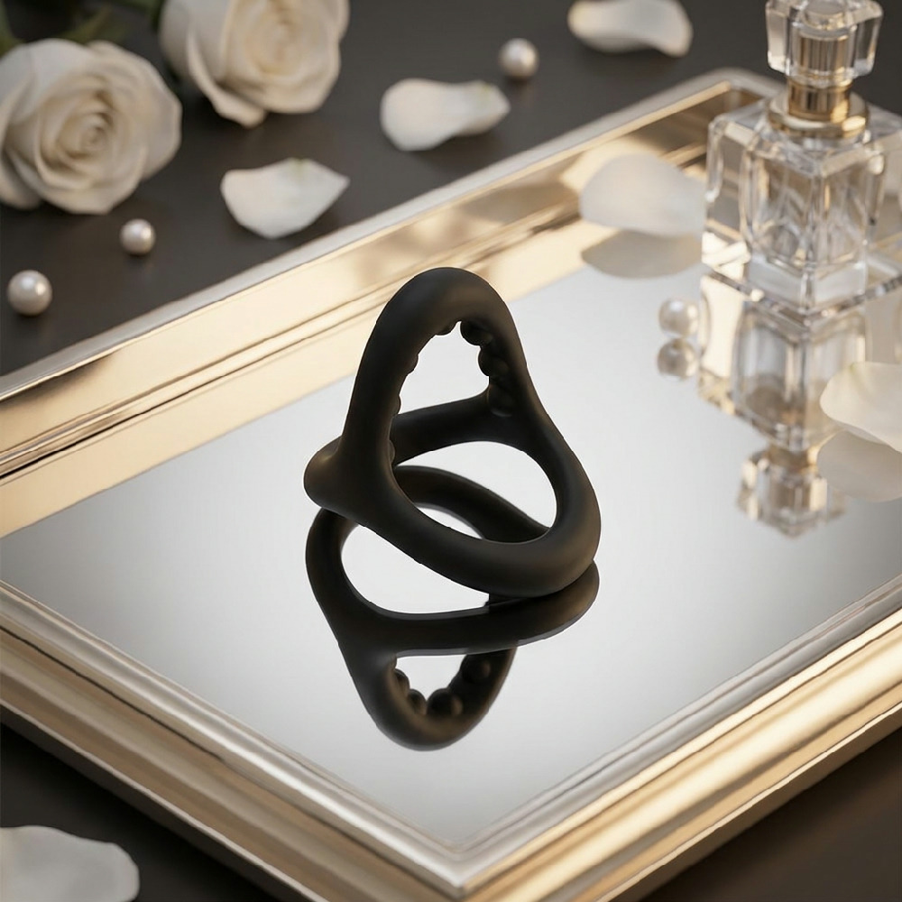 Anel Peniano e Escrotal Otto Preto em cen�rio sensual com flores e espelho, destacando o design