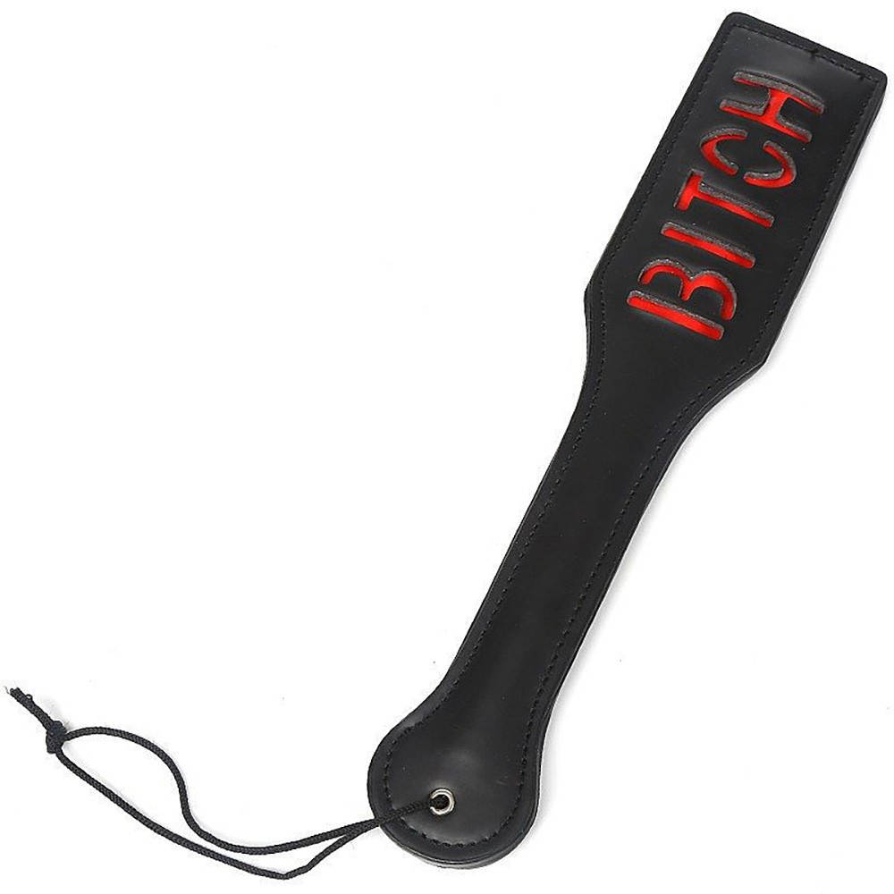 Palmat�ria Bitch preta com detalhes vermelhos em imita��o de couro, vista lateral