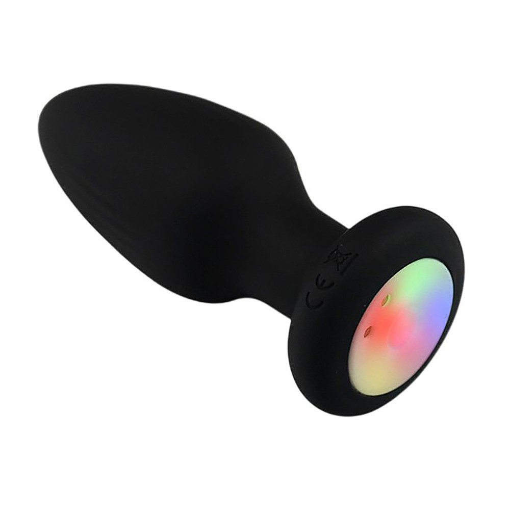 Plug anal vibrat�rio preto com parte traseira em detalhe, mostrando o disco colorido de LED e o ponto de carregamento