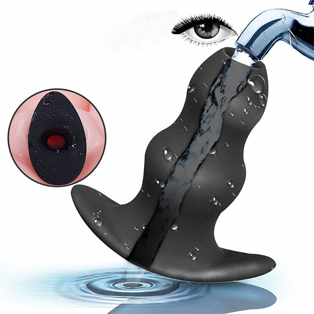 Plug Anal Graduado Oco de Silicone Preto sendo lavado sob �gua corrente, ilustrando sua caracter�stica � prova de �gua