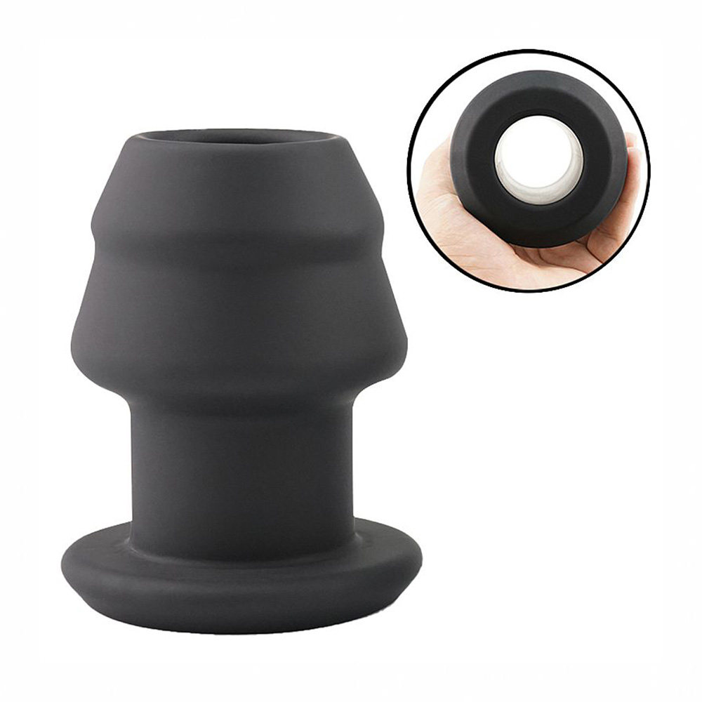 Plug Anal Oco com Abertura para Inser��es em silicone preto, mostrando uma vista de perfil do produto em �ngulo lateral, com a base de seguran�a e a silhueta da abertura central