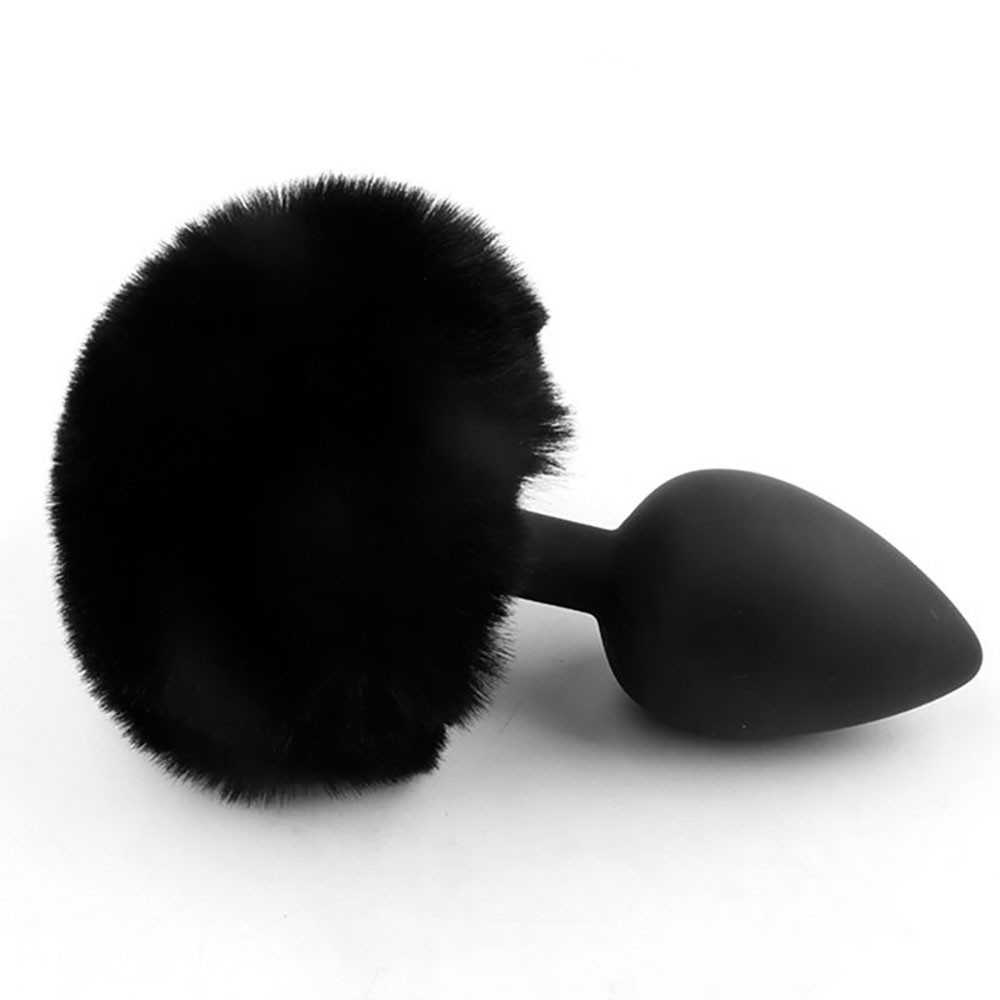 Plug anal de silicone preto com a cauda de coelho em close-up, destacando a textura macia