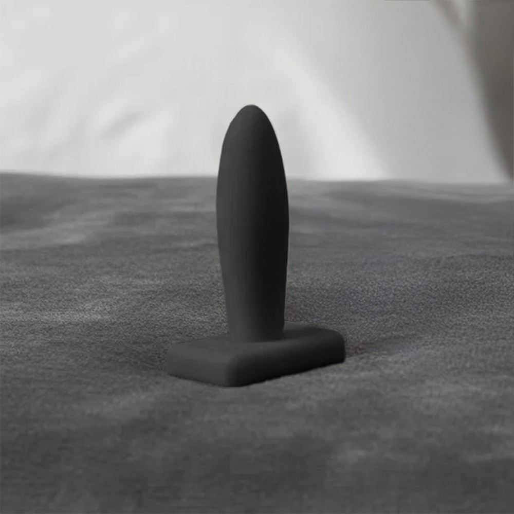 Plug anal preto em PVC flex�vel em ambiente discreto, destacando seu design ergon�mico e acabamento macio