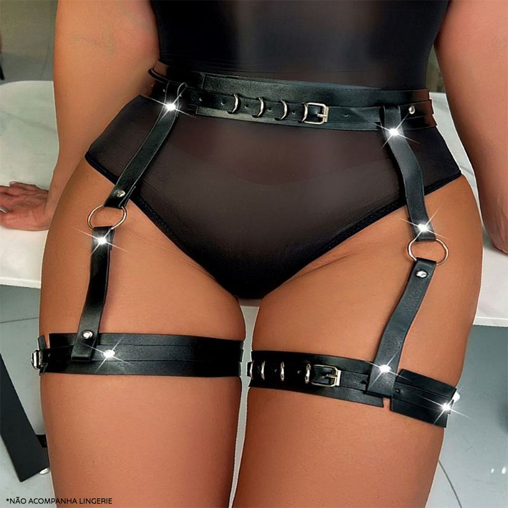 Modelo usando o harness em PU preto, vista frontal destacando as fivelas na cintura e ligas de coxa.
