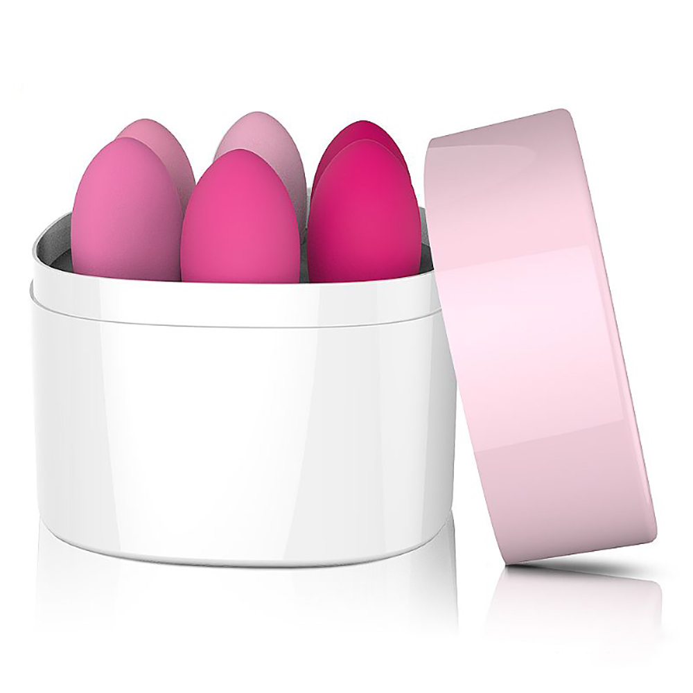 Detalhe do kit de bolas de pompoarismo dentro da caixa branca, com a tampa rosa ao lado