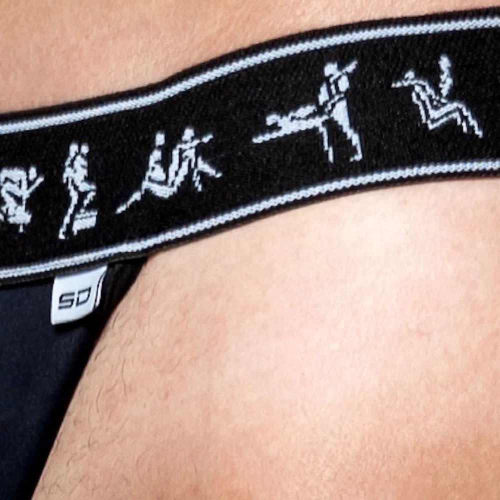 Close na frente da Cueca Sensual Jockstrap KamaSutra Gay Preta, focando na pouch de suplex e no el�stico detalhado.