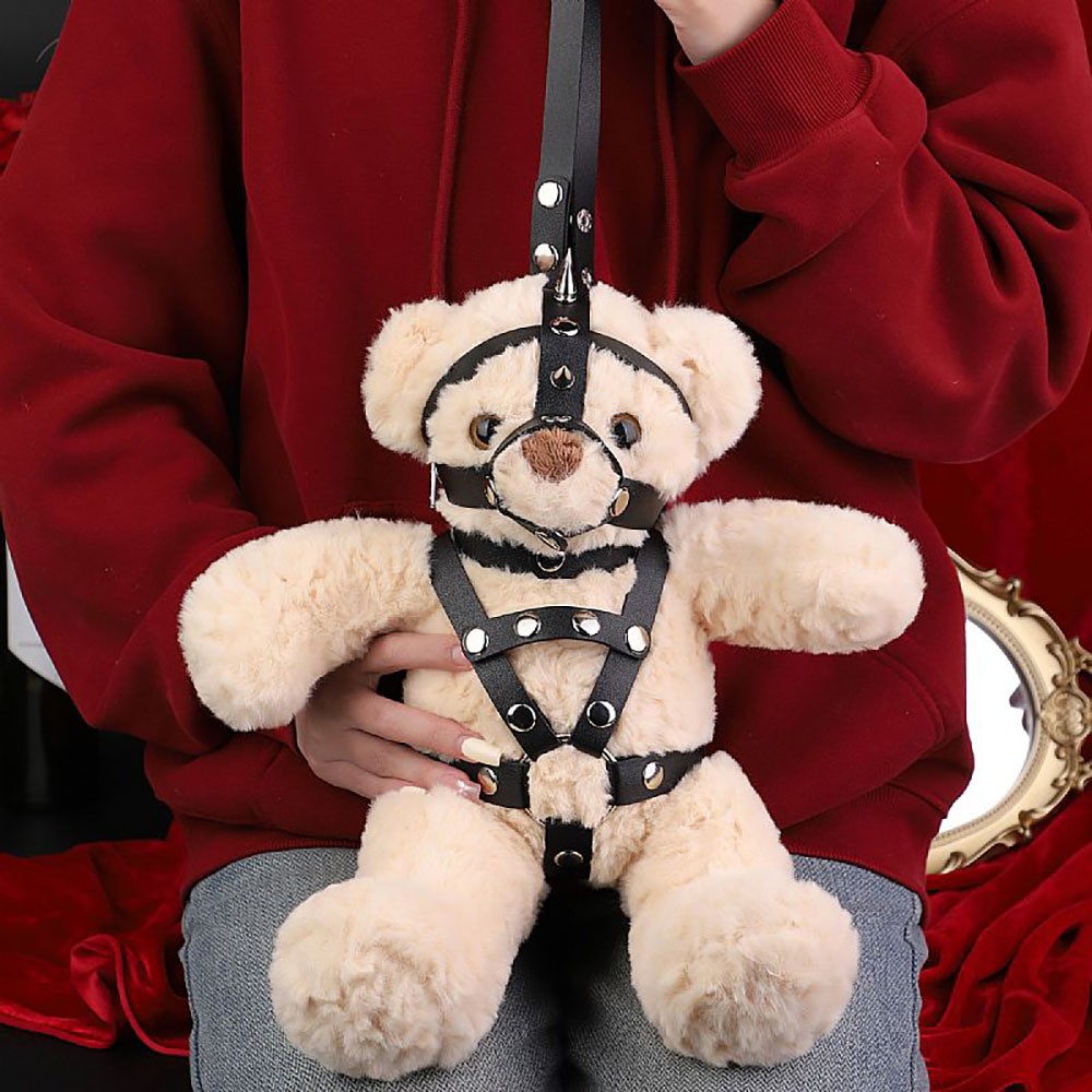 Ursinho Sado Billy Bondage James em pel�cia bege com harness preto e rebites, segurado por m�os