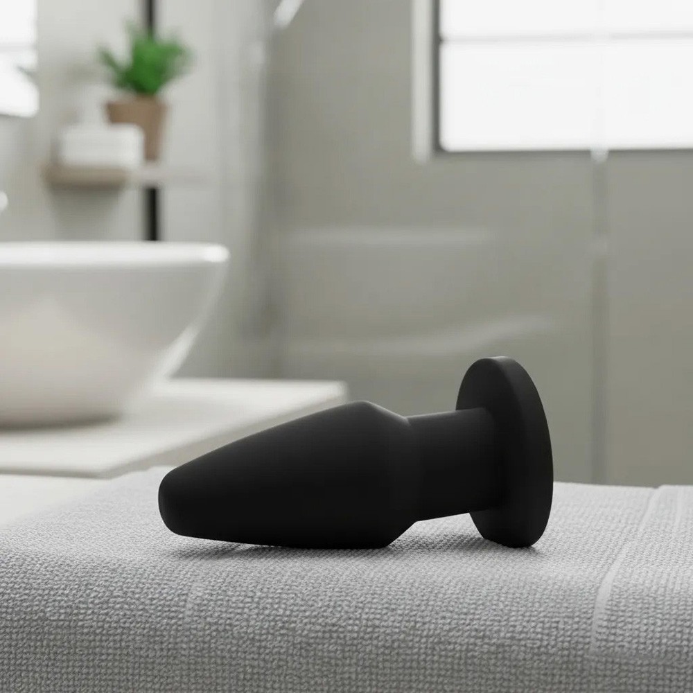Plug anal de PVC flex�vel na cor preta, visto em um �ngulo de tr�s quartos, real�ando sua forma c�nica e base redonda